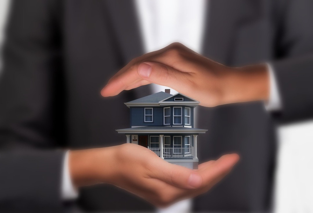 home insurance hands protecting house